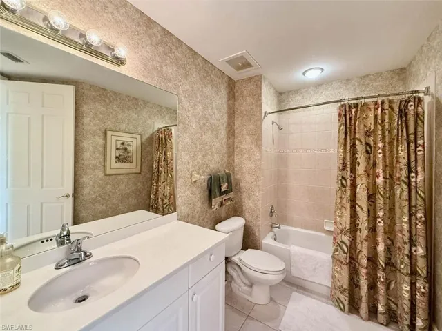 Full bathroom featuring shower / bath combo, tile patterned flooring, and vanity