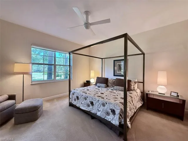 Carpeted bedroom featuring a ceiling fan