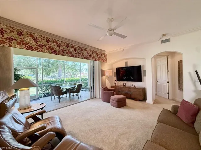 Carpeted living room with entertainment niche and surround speakers