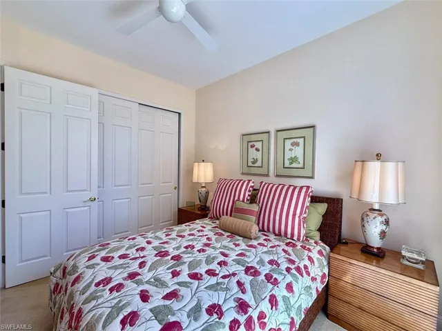 Carpeted bedroom featuring a closet and ceiling fan