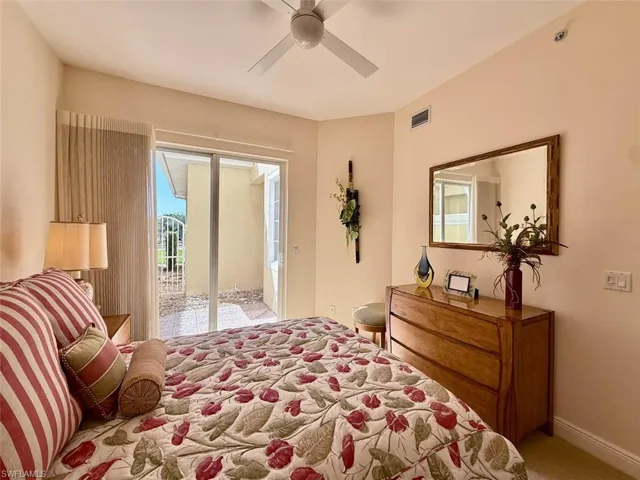 Carpeted bedroom with baseboards, access to patio, and ceiling fan