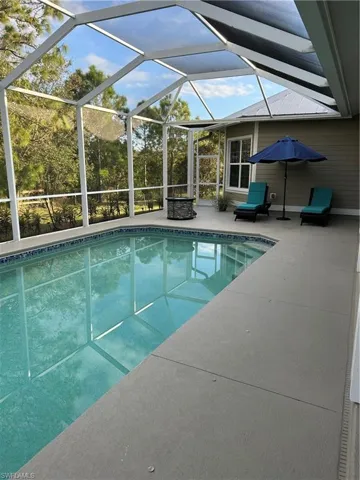 View of swimming pool featuring a lanai and a patio area