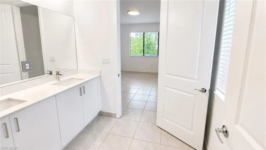 Dual vanity with white cabinetry, integrated sinks, and polished chrome faucets