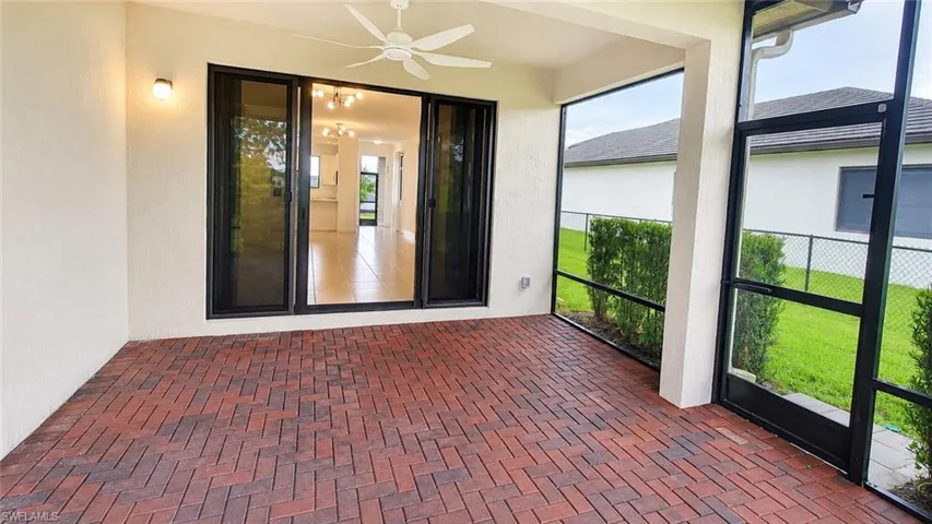 Screened patio featuring brick paver flooring and an outdoor ceiling fan