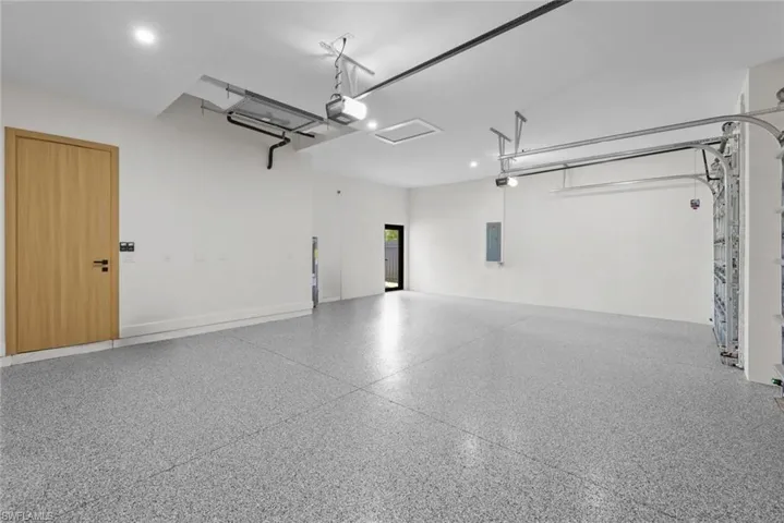 Garage featuring electric panel and a garage door opener