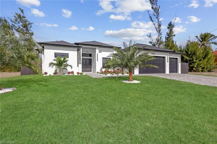 View of front of home featuring a front yard and a garage