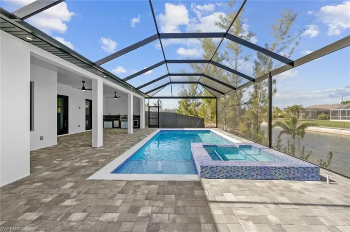 View of pool featuring a lanai, a patio, and an in ground hot tub