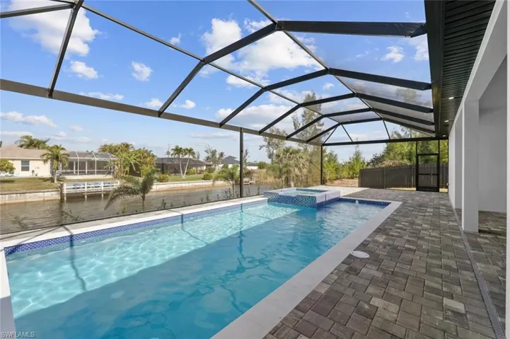 View of pool with an in ground hot tub, a lanai, and a patio area