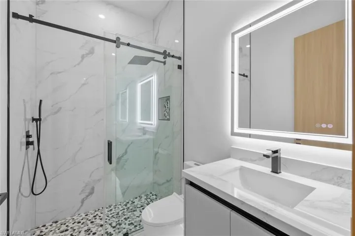 Bathroom with walk in shower, vanity, and toilet
