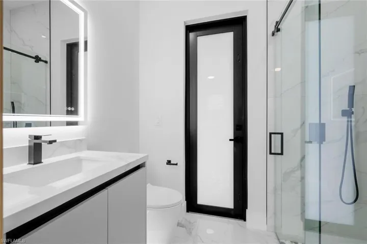 Bathroom with walk in shower, vanity, and toilet