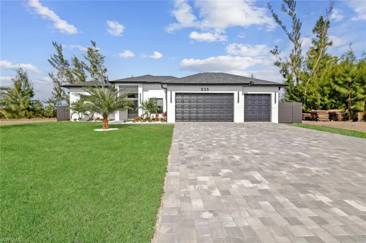 View of front facade featuring a front lawn and a garage
