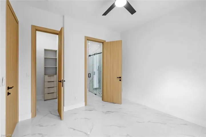 Bedroom with ceiling fan and a walk in closet