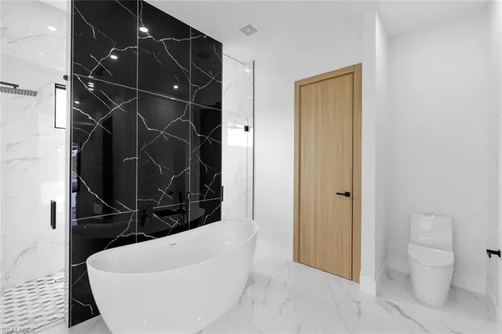 Bathroom featuring separate shower and tub and toilet