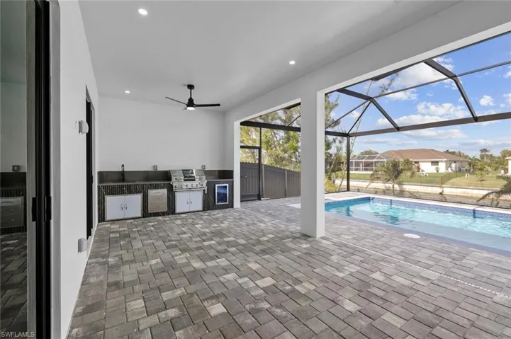 View of swimming pool featuring exterior kitchen, a patio area, sink, and area for grilling