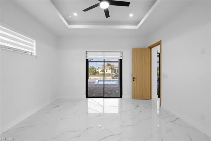 Empty room with a raised ceiling and ceiling fan