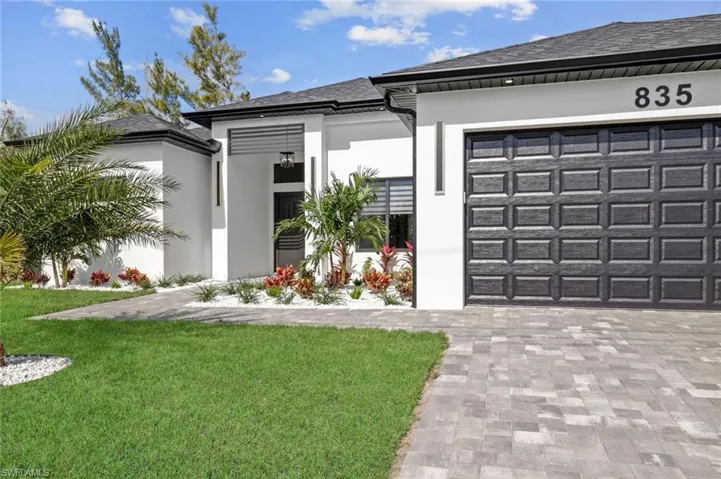 View of front of home with a garage and a front lawn