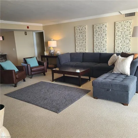 Living room with light colored carpet and crown molding