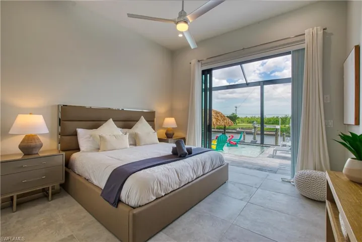 Spacious room with large format tile flooring and a vaulted ceiling featuring a ceiling fan