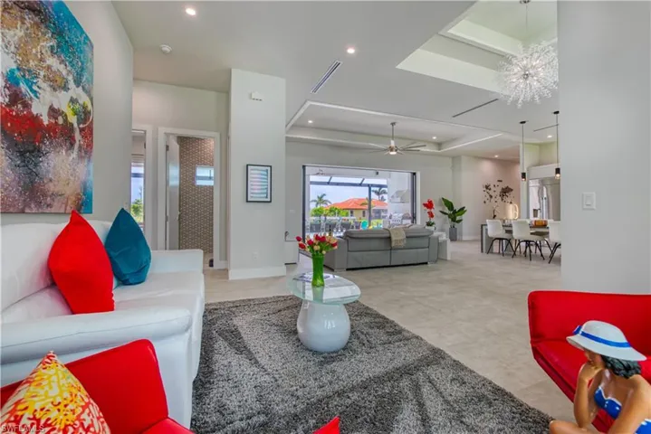 Spacious open-concept interior featuring light-toned flooring, recessed lighting, and a tray ceiling