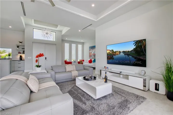 Great room featuring high ceilings with recessed lighting, a tray ceiling detail, and a ceiling fan