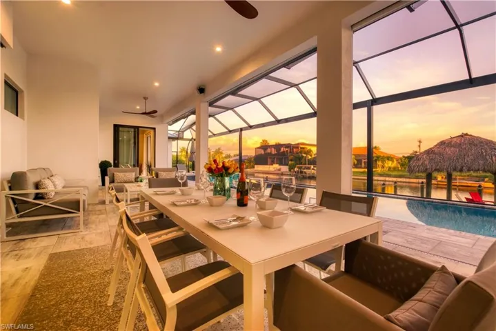 Screened lanai featuring a dining area with recessed lighting and a ceiling fan