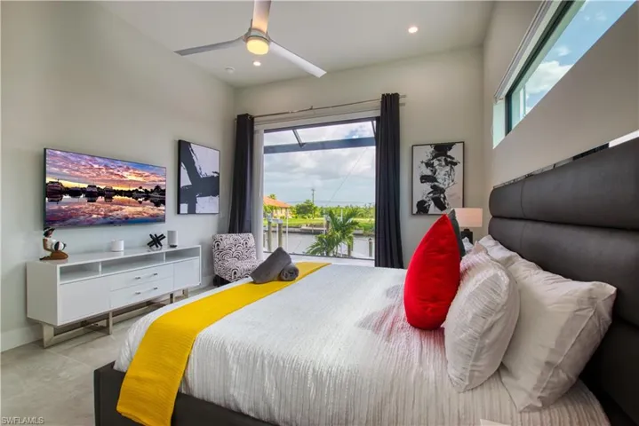 Bedroom with floor-to-ceiling windows, waterfront scenery, high ceilings, and recessed lighting