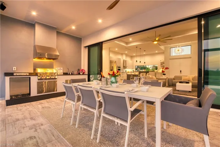 Covered patio featuring an outdoor kitchen with stainless steel appliances, a range hood, and a built-in refrigerator