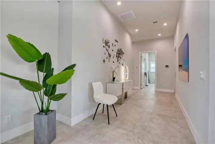 Hallway featuring light-toned tile flooring and recessed ceiling lighting