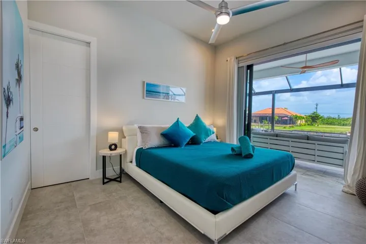 Spacious room featuring large format tile flooring, a modern ceiling fan, and a contemporary white door