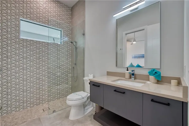 Contemporary bathroom featuring a floating vanity with a light-toned countertop and an integrated rectangular sink