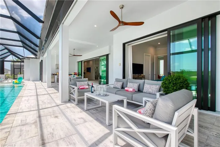 Expansive screened lanai with a swimming pool and light-toned tile flooring