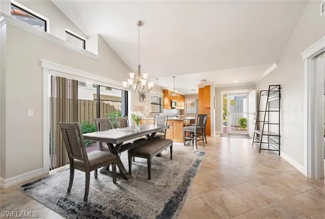 Tiled dining room with high vaulted ceiling and an inviting chandelier