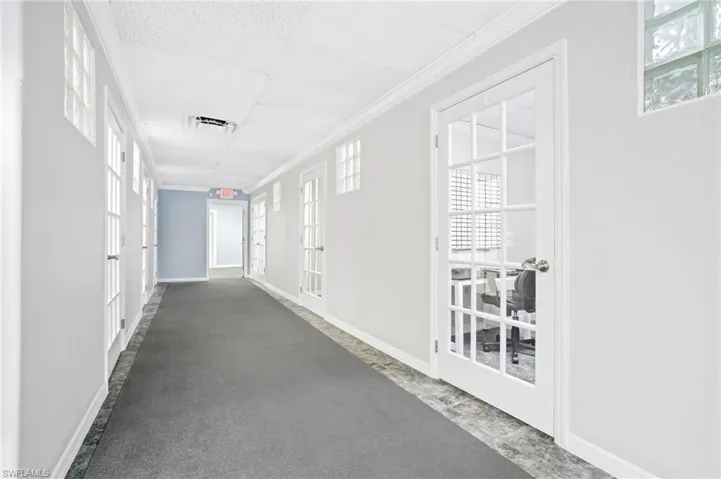 Corridor featuring ornamental molding and french doors