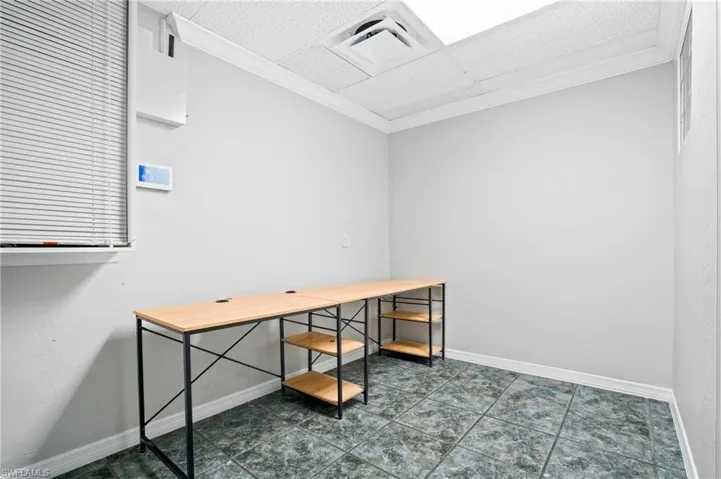Office with a paneled ceiling and ornamental molding