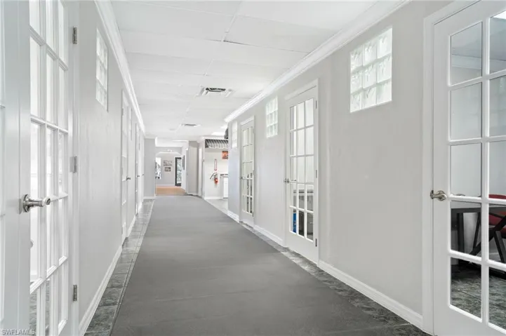 Hall featuring a drop ceiling, ornamental molding, and french doors