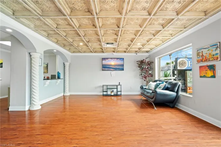 Entry way featuring ornate columns, crown molding, and hardwood / wood-style floors