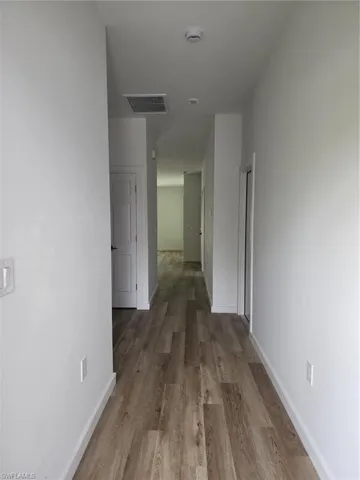 Hallway featuring wood finished floors and baseboards