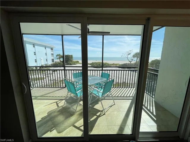 Balcony with a sunroom, a water view, and outdoor dining space