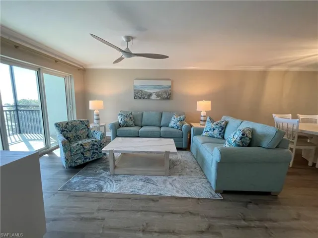 Living area with ornamental molding, wood finished floors, and a ceiling fan