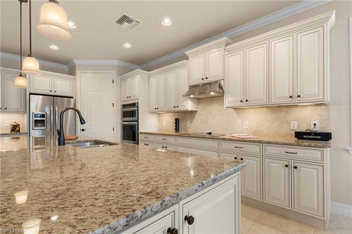 15045 Malayan Court Bonita Springs FL 34135 -Gourmet kitchen with beautiful creamy cabinets, double ovens and a cooktop