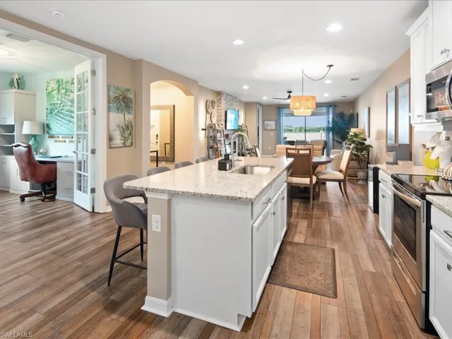 Kitchen featuring sink, white cabinetry, wood-type flooring, and appliances with stainless steel finishes