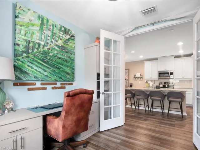 Home office with french doors and hardwood / wood-style flooring