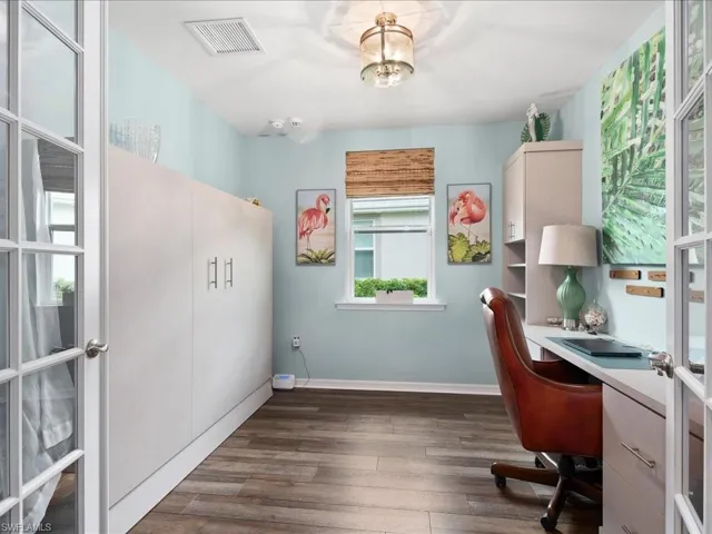 Office with dark hardwood / wood-style flooring and french doors