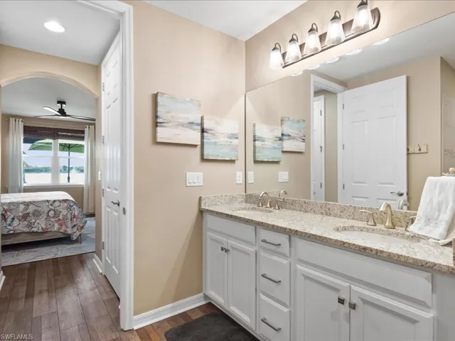 Bathroom featuring ceiling fan, wood-type flooring, and double sink vanity