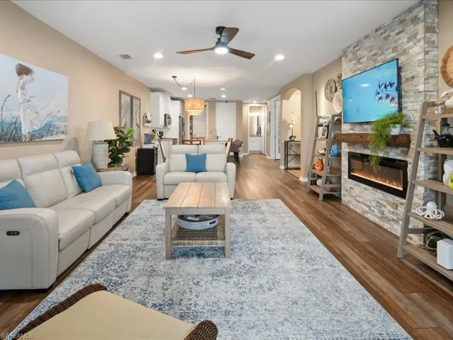 Living room featuring dark hardwood / wood-style flooring, a fireplace, and ceiling fan