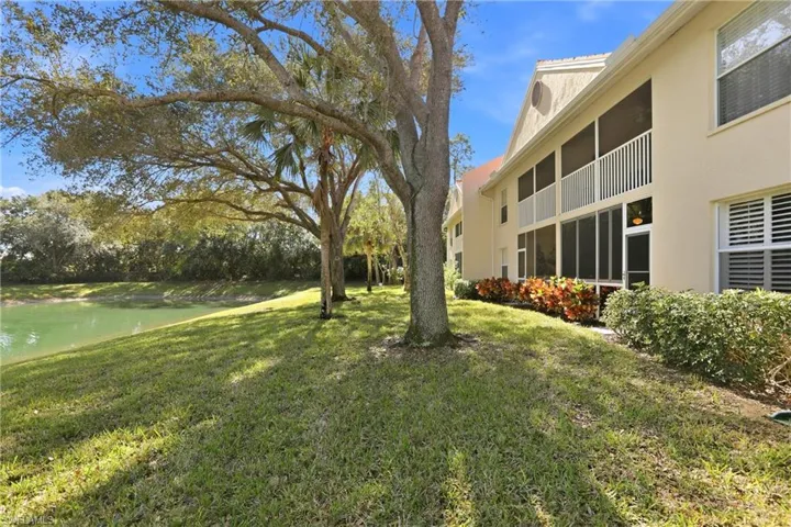 View of green lawn featuring a sunroom and a balcony