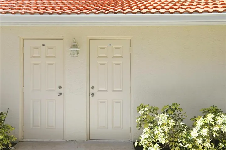 Doorway to property with a tiled roof and stucco siding