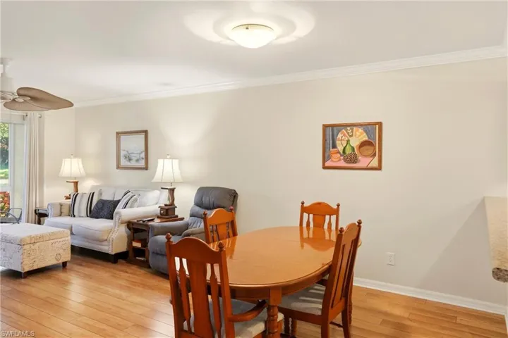 Dining room featuring light wood-style flooring, crown molding, and ceiling fan