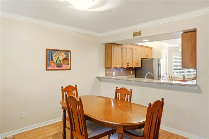 Dining space with crown molding and light wood finished floors