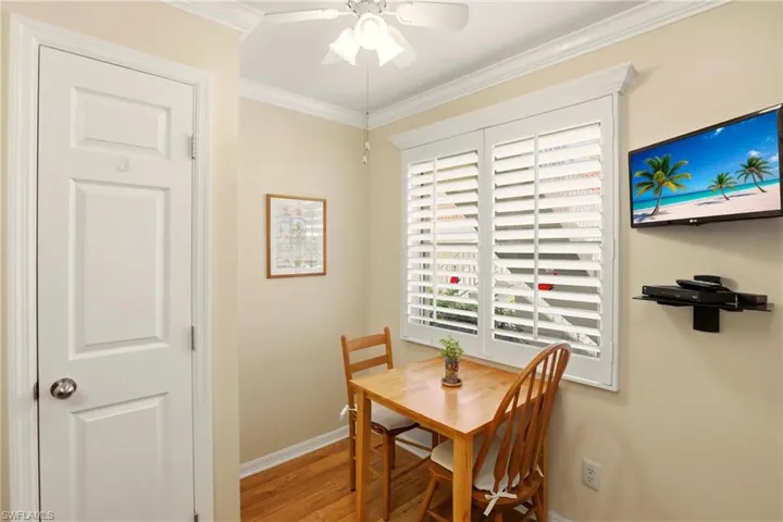 Dining area with ornamental molding, light wood-style floors, and ceiling fan